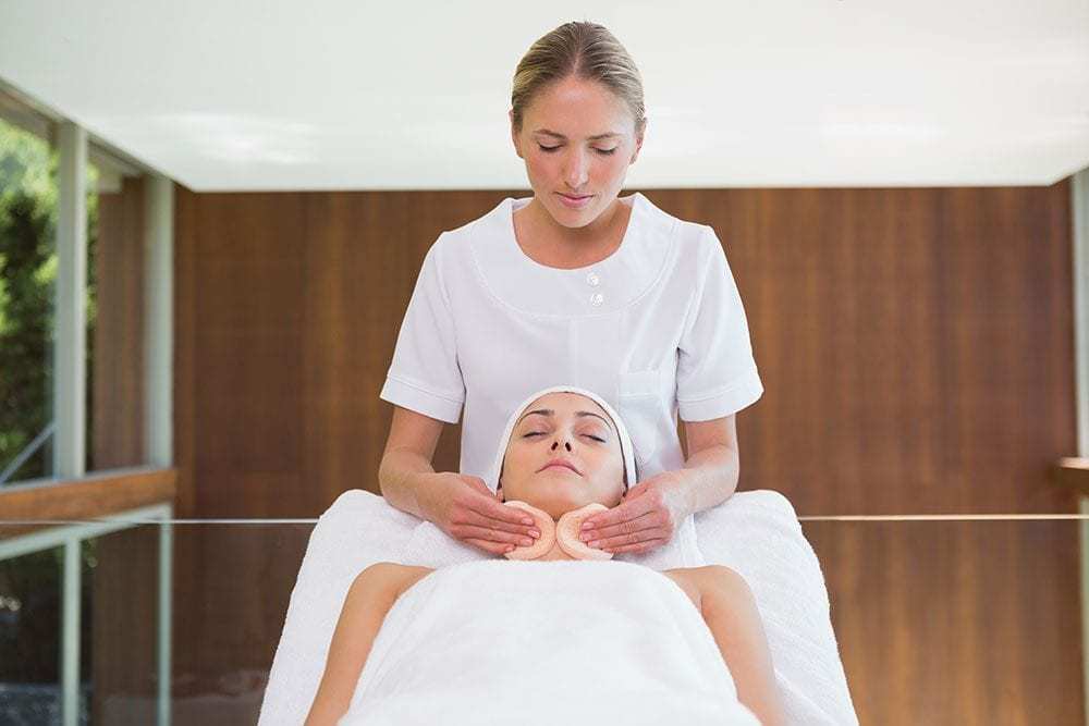 Getting facial from beauty therapist