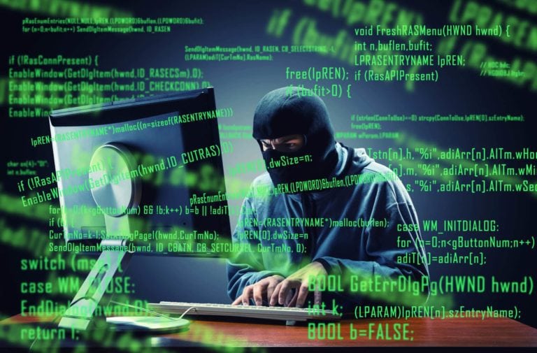 Hacker in mask stealing information in the office