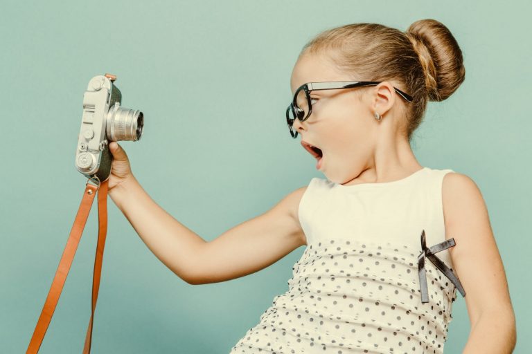 child holding a instant camera
