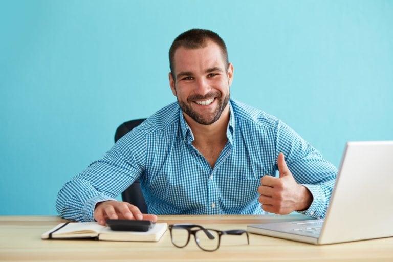Smiling businessman calculates taxes and gesturing thumbs up